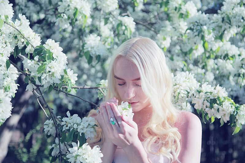 Mindulness of the four elements. Woman smelling white blossom
