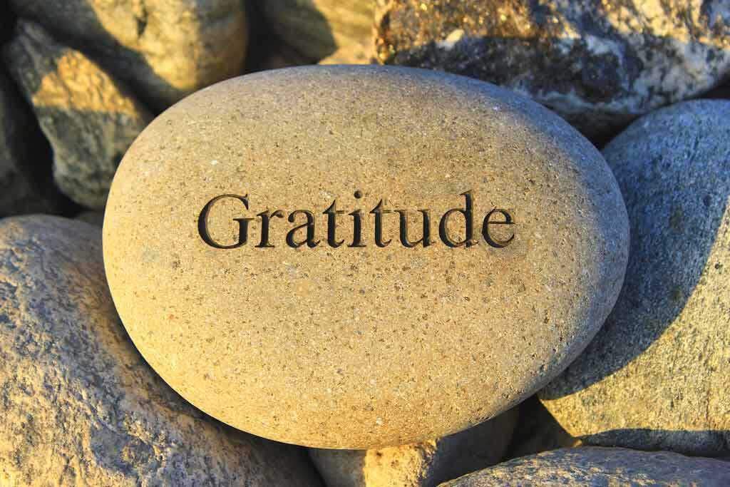 Gratitude written on a beach stone